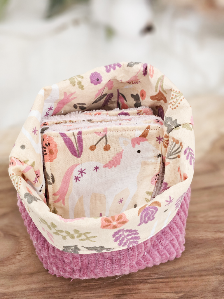 Panière en velours côtelé vieux rose intérieur tissus beige et décors licornes avec lingettes licornes et éponge bambou rose pastel.