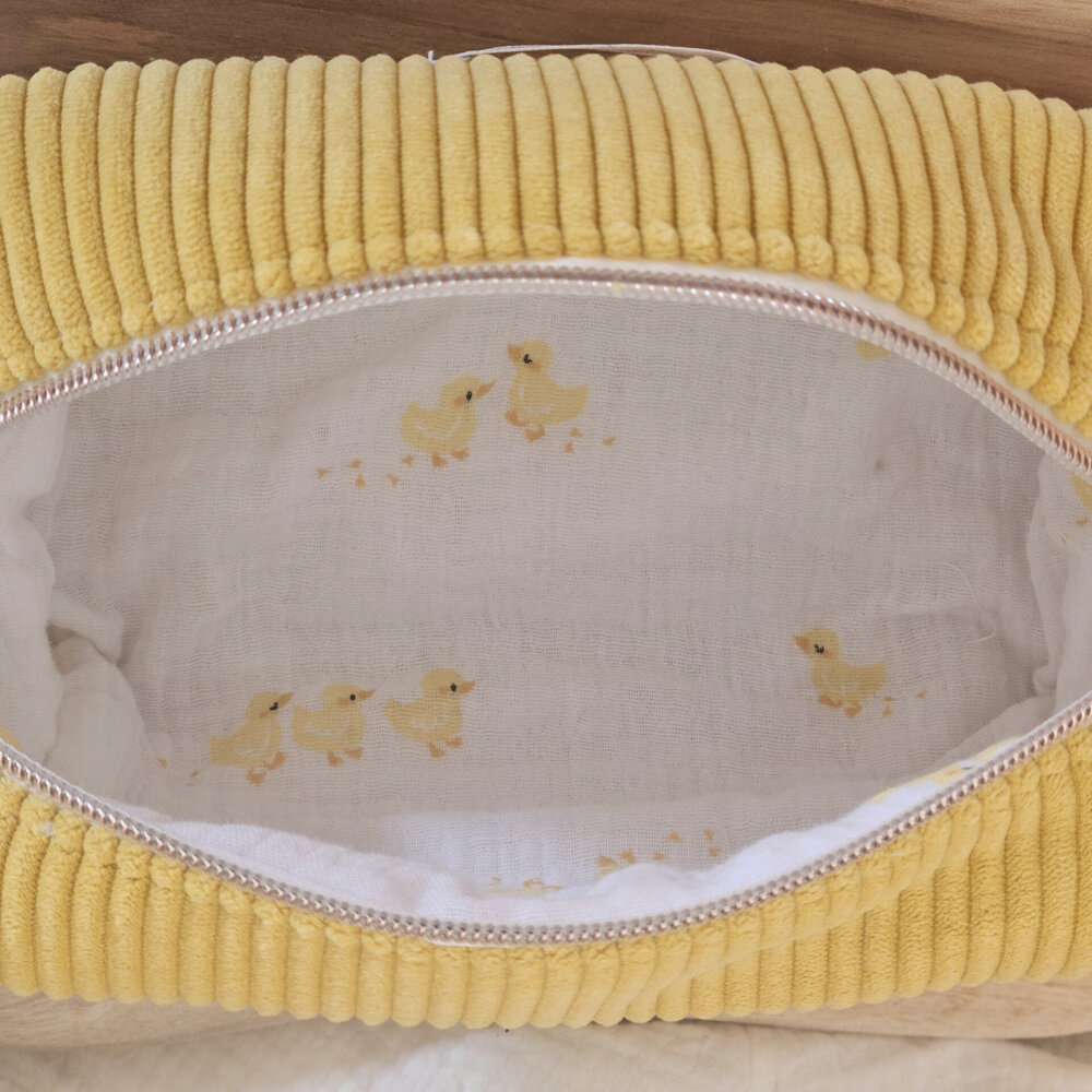 Trousse velours côtelé jaune marque Bloom créations, intérieur gaze de coton blanche ornée de petits poussin jaunes.