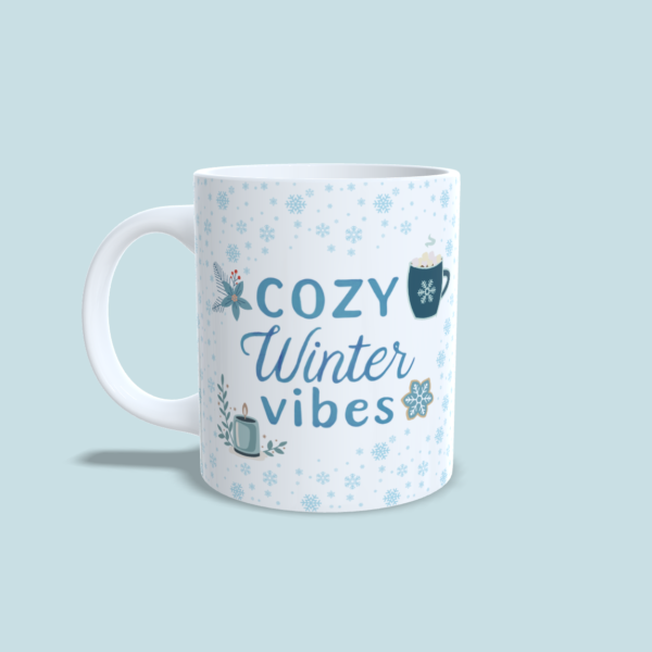 Mug "cozy winter vibes" flocons bleus et illustrations mugs, biscuits, bougies, fleurs bleues, anse gauche.