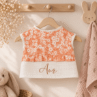 Bavoir couvrant orange et blanc à petites fleurs sur porte manteau